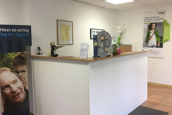 Empfangsbereich eines Hörgeräteakustikers mit Infomaterial und Werbung für Hörgeräte.